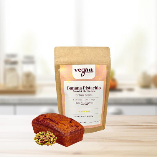 A packaged banana pistachio bread mix with a small loaf of banana pistachio bread in the foreground, set on a kitchen counter.